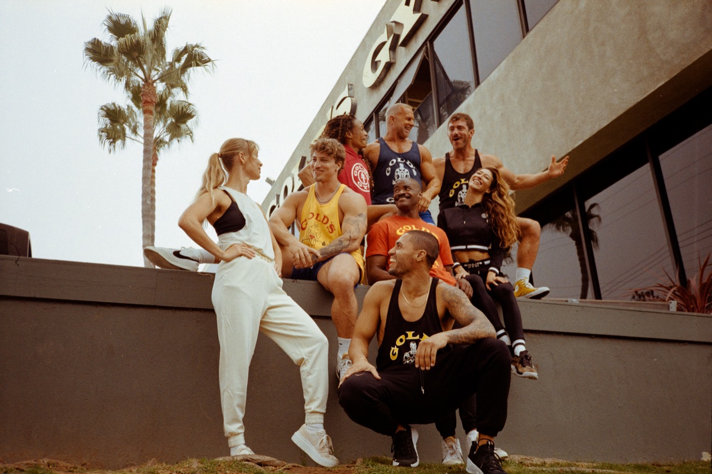Grupo de atletas reunido na entrada da Gold's Gym de Venice Beach